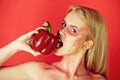 Woman bite paprika on the red background, heart Royalty Free Stock Photo