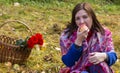 A woman bites an Apple at a picnic in the Park. Basket with roses, apples