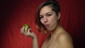 A woman bites off a juicy green apple