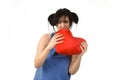 Woman biting in rage spiteful and resentful a red heart shape pillow upset