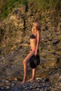 woman in black bikini posing on a sand rocks Royalty Free Stock Photo