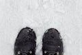 A woman in black boots stands on the snow in winter Royalty Free Stock Photo