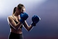 Woman with black boxing wraps and boxing gloves on hands boxing