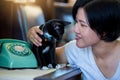 Woman and black cat sitting with Retro rotary telephone on wooden table Royalty Free Stock Photo