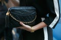 Woman with black Chanel leather bag and golden watch before Luisa Beccaria fashion show, Milan Fashion Week