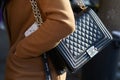 Woman with black Chanel leather bag with silver chain and beige coat before MSGM fashion show, Milan Fashion