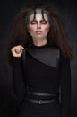 Woman in black clothes with expressive dark makeup