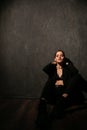 Woman in black clothes posing in a dark room Royalty Free Stock Photo