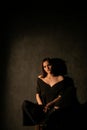 Woman in black clothes posing in a dark room Royalty Free Stock Photo
