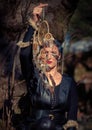 A woman in black clothing holds a Dreamcatcher amulet in a forest in Greece