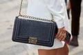 Woman with black crocodile leather Chanel bag before Tiziano Guardini fashion show, Milan