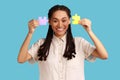 Woman with black dreadlocks showing to camera two pieces of puzzles, solving task.