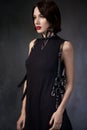 Woman in black dress with leather accessories