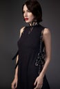 Woman in black dress with leather accessories