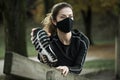 Woman with black face mask exercising in park during covid-19 epidemy