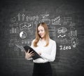 Woman with a black folder near a startup idea sketch on a chalkboard Royalty Free Stock Photo