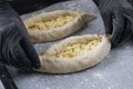 Woman in black gloves holds raw khachapuri. Process of making bakery. Adjarian Khachapuri Recipe Ã¢â¬â Georgian cheese bread Royalty Free Stock Photo