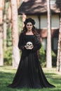 woman in black halloween costume holding