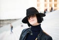 Woman in black hat and jacket pose on stairs Royalty Free Stock Photo