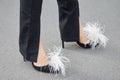 Woman with black high heel shoes with white feathers before Prada fashion show, Milan Fashion