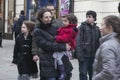 A woman in a black jacket holding her baby girl in a red coat. They look at the performance of the actors, Covent Garden Royalty Free Stock Photo