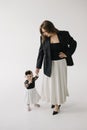 a woman in a black jacket is sitting next to a little girl in a white dress Royalty Free Stock Photo