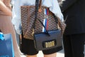 Woman with black leather bag with golden Dior logo before Pal Zileri fashion show, Milan Fashion Week street