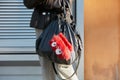 Woman with black leather bag with red fur accessory before Emporio Armani fashion show, Milan Fashion Week Royalty Free Stock Photo