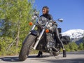 A Woman In A Black Leather Biker Jacket On A Chopper Motorcycle In Greece On A Road In The Forest In The Mountains