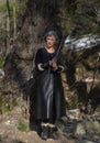 A woman in a black leather suit with a sword in the woods Royalty Free Stock Photo