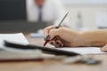 Woman with a black manicure writes a document, contract or resume, fills out the form with a fountain pen. Without a face. Royalty Free Stock Photo