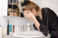 woman in a black negligee washes her face in the bathroom Royalty Free Stock Photo