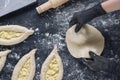 Woman in black shirt and black gloves holds rolled out yeast dough. Process of making bakery. Adjarian Khachapuri Recipe Ã¢â¬â Royalty Free Stock Photo