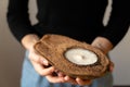 Woman in black shirt holding candle in coconut.