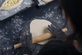 Woman in black shirt rolling out yeast dough with a rolling pin. Process of making bakery. Adjarian Khachapuri Recipe Ã¢â¬â Georgian Royalty Free Stock Photo