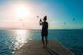 Woman in black sundress in a deck looking people doing kite surf Royalty Free Stock Photo