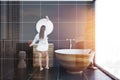 Woman in black tile bathroom interior, wooden tub Royalty Free Stock Photo