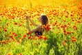 Woman in field of poppy making selfie photo with phone