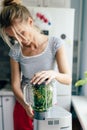Woman blender vegetables and greens. Cooking a green spring smoothie. Mixing in a blender bowl Royalty Free Stock Photo