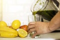 Woman blending spinach, bananas, lemon and apples to make a heal