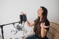 Woman blogger recording radio podcast in studio.