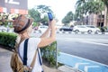 Woman blogger taking photo with her smartphone in Kuala-Lumpur. Travel in Asia concept.