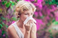 Woman with allergy symptom blowing nose