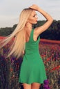 Woman with blond hair in elegant dress posing at summer blossom lavender field Royalty Free Stock Photo