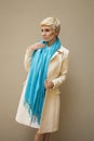 Woman blonde in white coat, blue scarf. Fashion hairstyle, make-up. Royalty Free Stock Photo