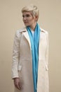 Woman blonde in white coat, blue scarf. Fashion hairstyle. Royalty Free Stock Photo