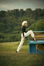 Woman in blonde wig playing piano in retro style interior with leg in shoe Royalty Free Stock Photo