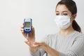 Woman with blood glucose meter, close-up