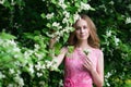 Woman in blooming summer garden in long pink dress, outdoor