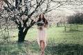 Woman in blooming trees. Woman with wedding bouquet in hands.